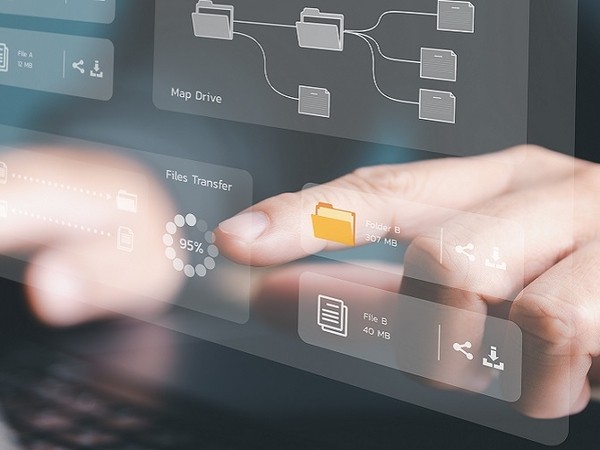 Close-up of a hand interacting with a transparent digital interface displaying file transfer progress at 95%, folder icons, and file details over a blurred laptop keyboard background.