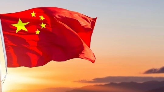 Chinese flag waving against a sunset sky with mountain silhouettes in the background